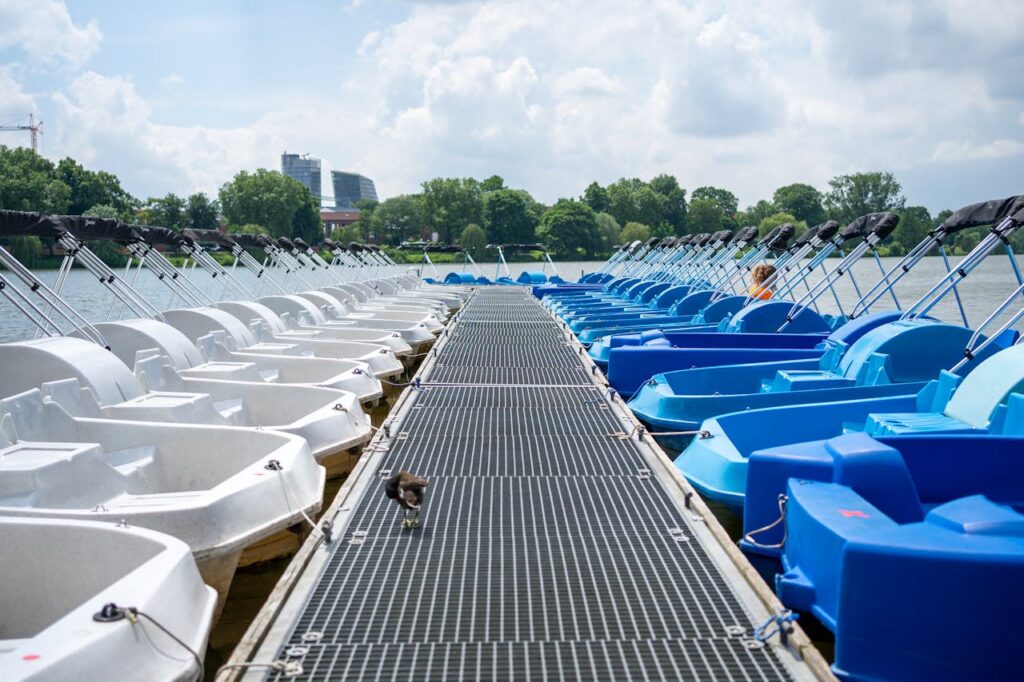 Blue and white paddleboats on a sunny day at a lake in Münster, Germany.